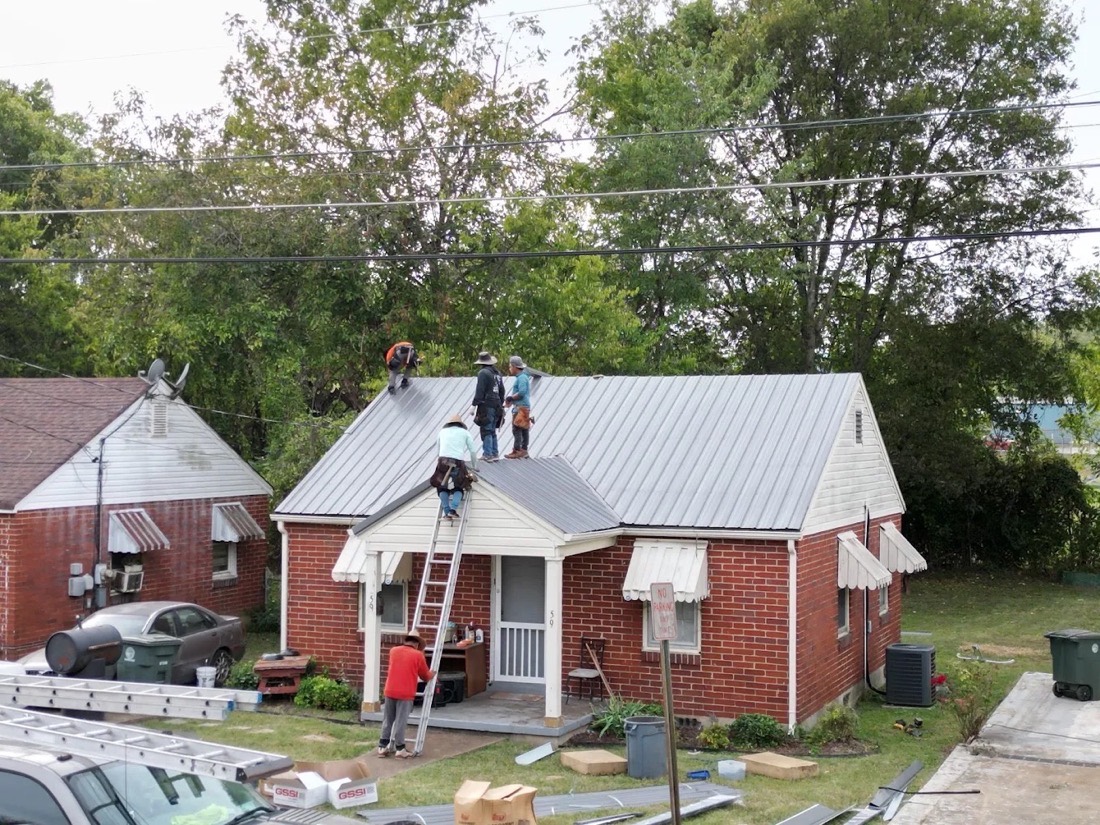 Roofing crew working on a residential metal roof