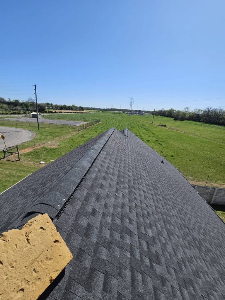 Completed asphalt shingle roof replacement viewed along ridge