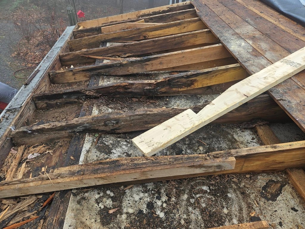 Deteriorated roof decking and framing exposed during roof tear-off