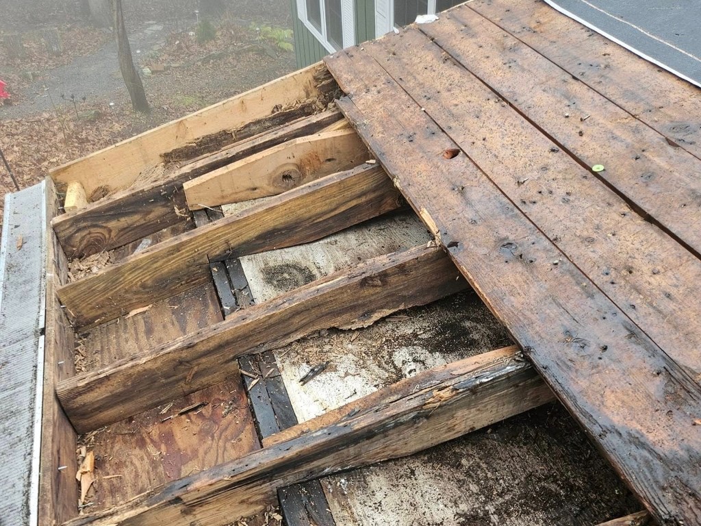 Close view of damaged roof framing and decking during replacement