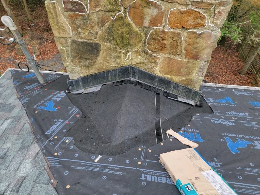 Chimney flashing and waterproofing work during roof replacement